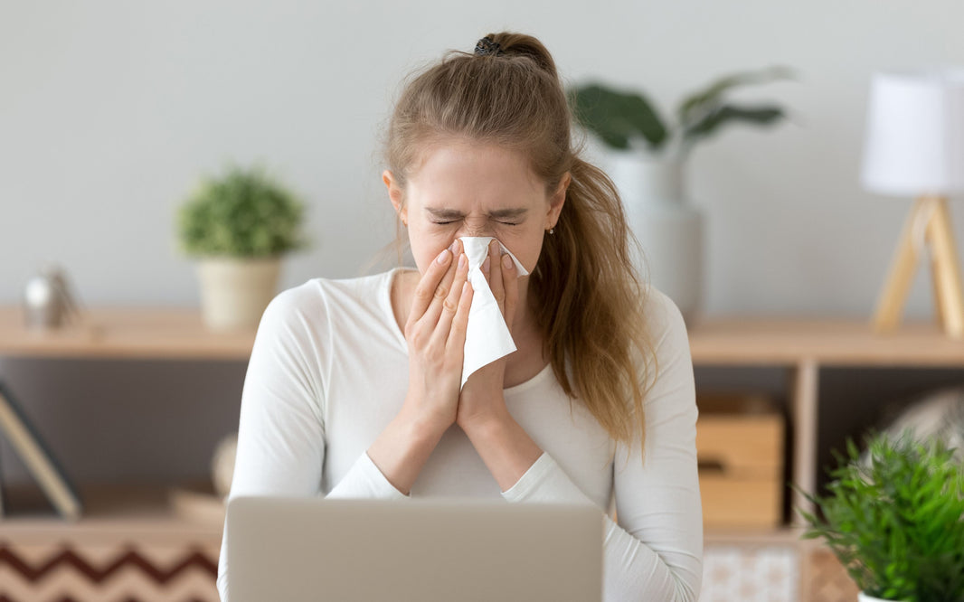 Woman blowing her nose into a tissue.